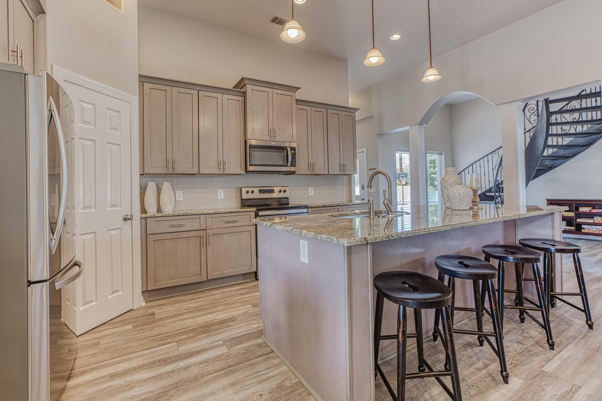 4583 Luke Avenue Destin, FL 32541 - Photo 10 of 86 a kitchen with kitchen island granite countertop wooden floors and white cabinets