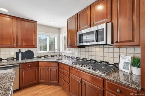 a kitchen with stainless steel appliances granite countertop a sink stove and cabinets