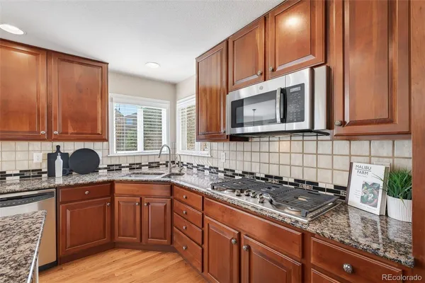 a kitchen with stainless steel appliances granite countertop a sink stove and cabinets