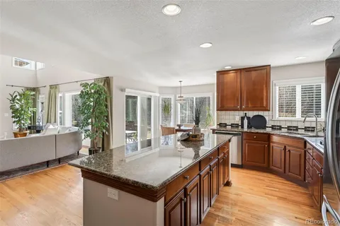 a kitchen with stainless steel appliances granite countertop sink stove top oven and cabinets