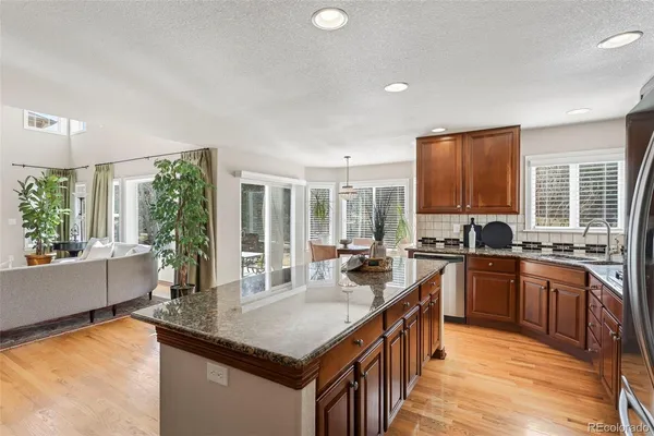 a kitchen with stainless steel appliances granite countertop sink stove top oven and cabinets