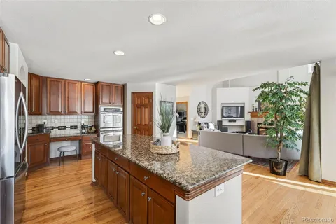 a kitchen with stainless steel appliances granite countertop sink stove top oven and cabinets