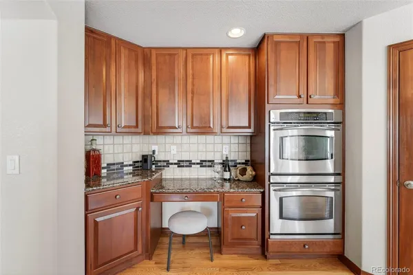 a kitchen with granite countertop wooden cabinets and stainless steel appliances
