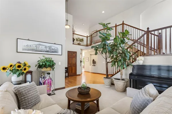 a living room with furniture flowerpot and a chandelier