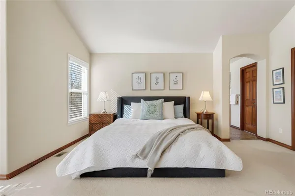 a bedroom with a large bed and a night stand