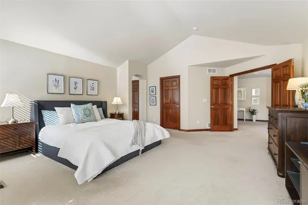 a spacious bedroom with a bed and cabinets