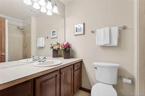 a bathroom with a sink vanity mirror and toilet