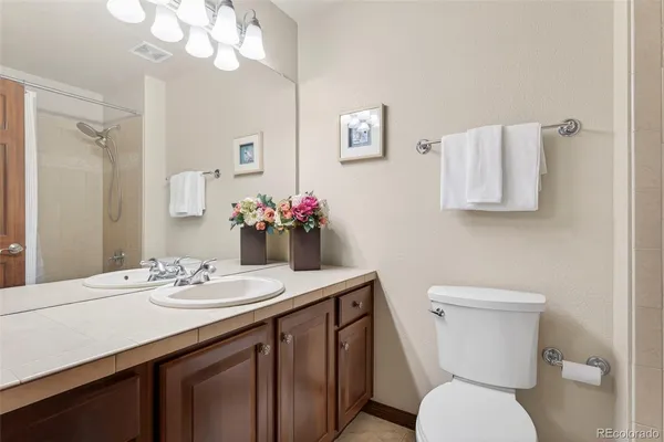 a bathroom with a sink vanity mirror and toilet