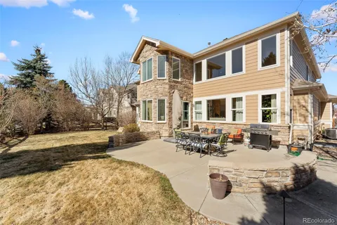 a front view of a house with a yard outdoor seating and covered with trees