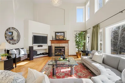 a living room with furniture a fireplace and a large window