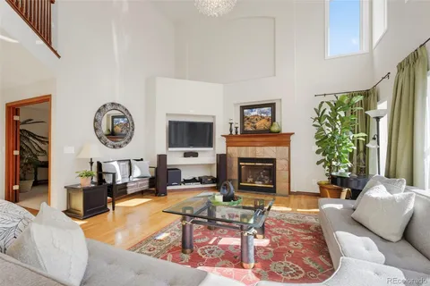 a living room with furniture a fireplace a clock and a large window