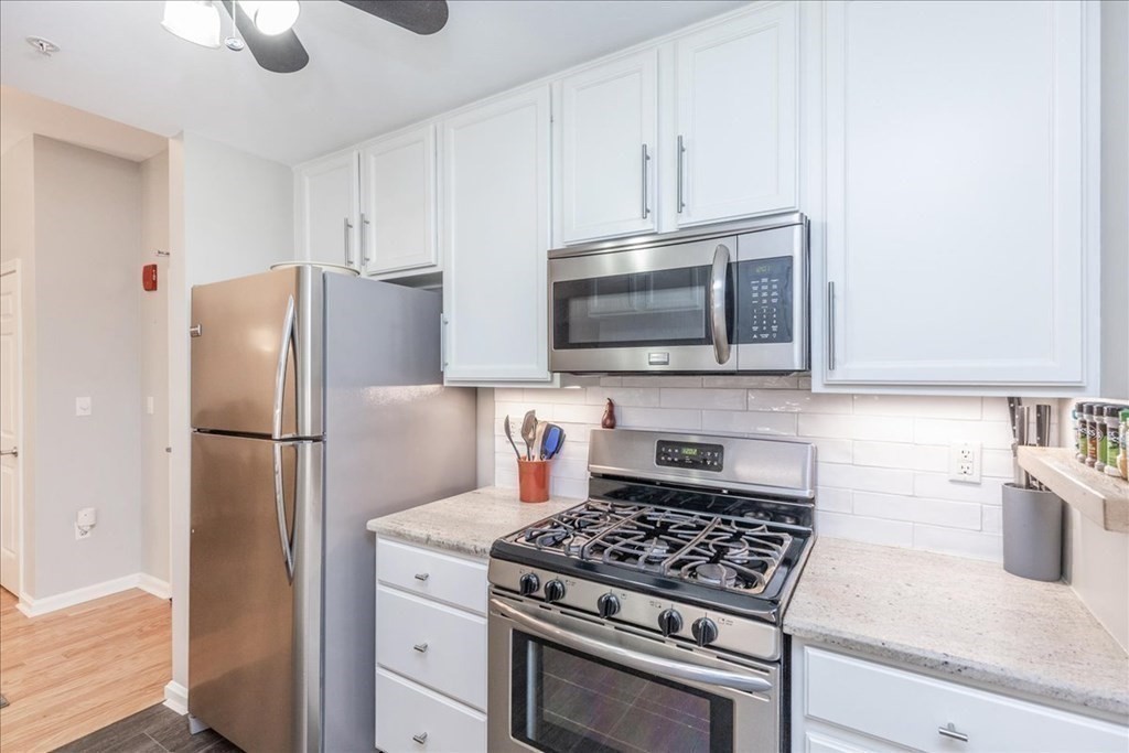 38 Village Road, Unit 312 Middleton, MA 01949 - Photo 12 of 42 a kitchen with stainless steel appliances granite countertop a stove a refrigerator and a microwave