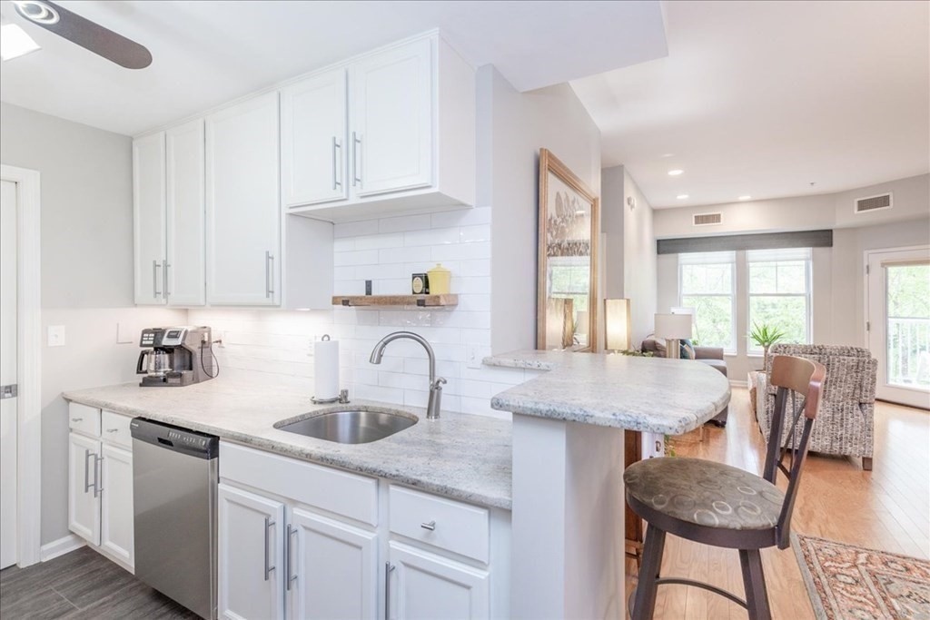 38 Village Road, Unit 312 Middleton, MA 01949 - Photo 14 of 42 a kitchen with granite countertop a sink a counter space and dining table