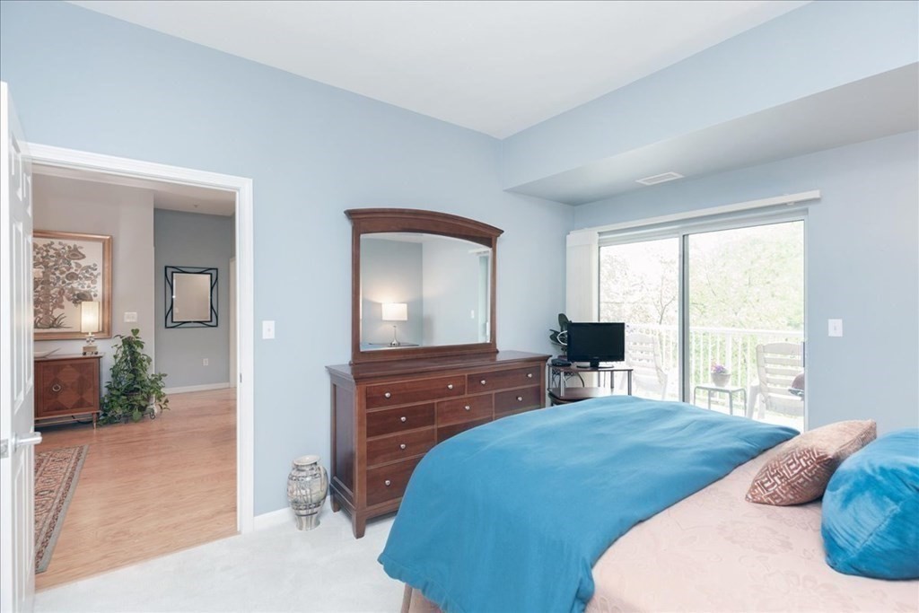 38 Village Road, Unit 312 Middleton, MA 01949 - Photo 22 of 42 a bedroom with a bed and a large window