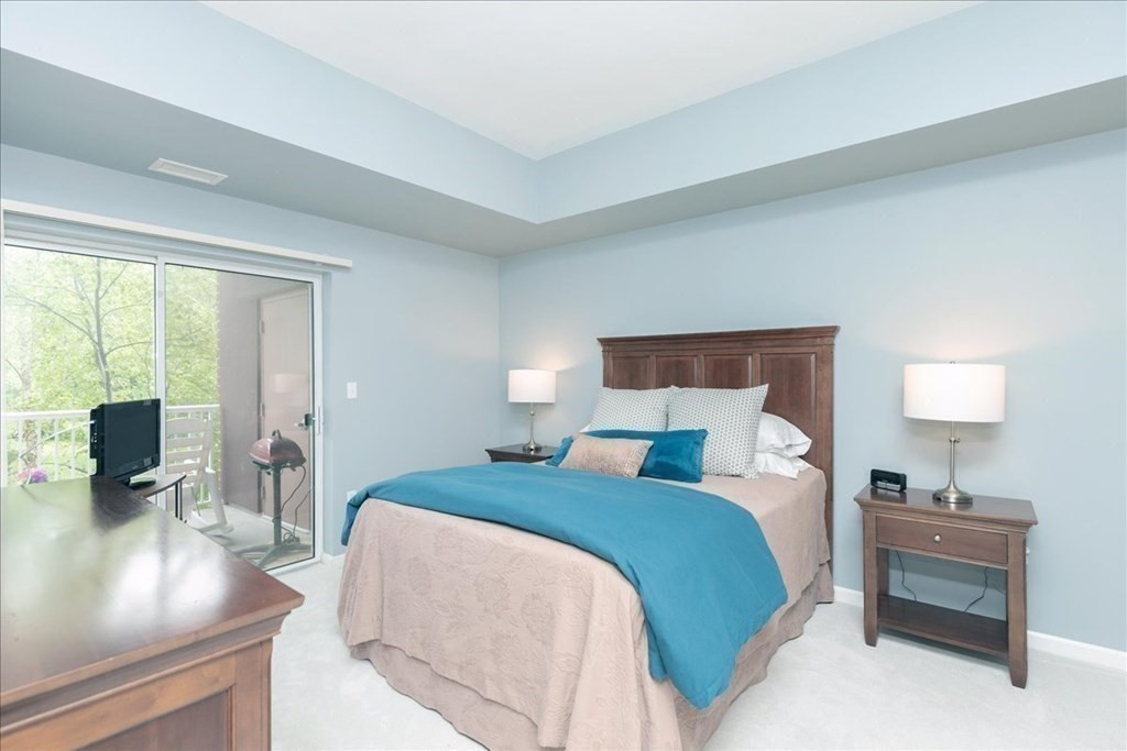 38 Village Road, Unit 312 Middleton, MA 01949 - Photo 24 of 42 a bedroom with a bed and large window