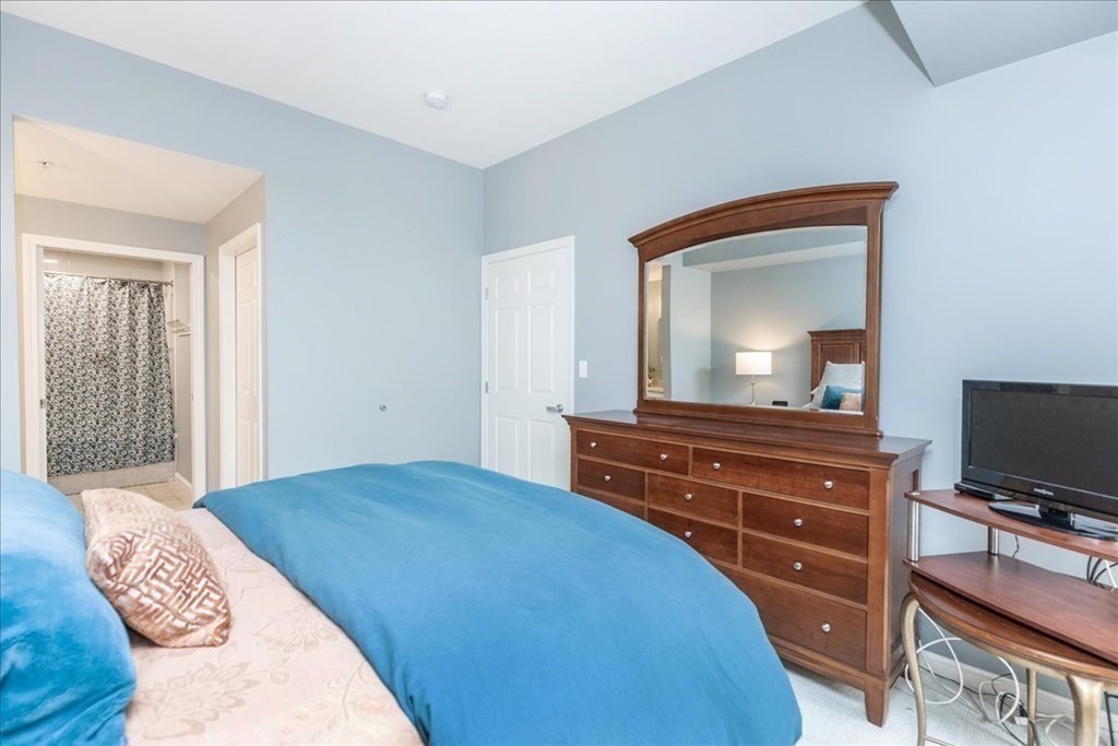 38 Village Road, Unit 312 Middleton, MA 01949 - Photo 25 of 42 a bedroom with a bed and a flat screen tv