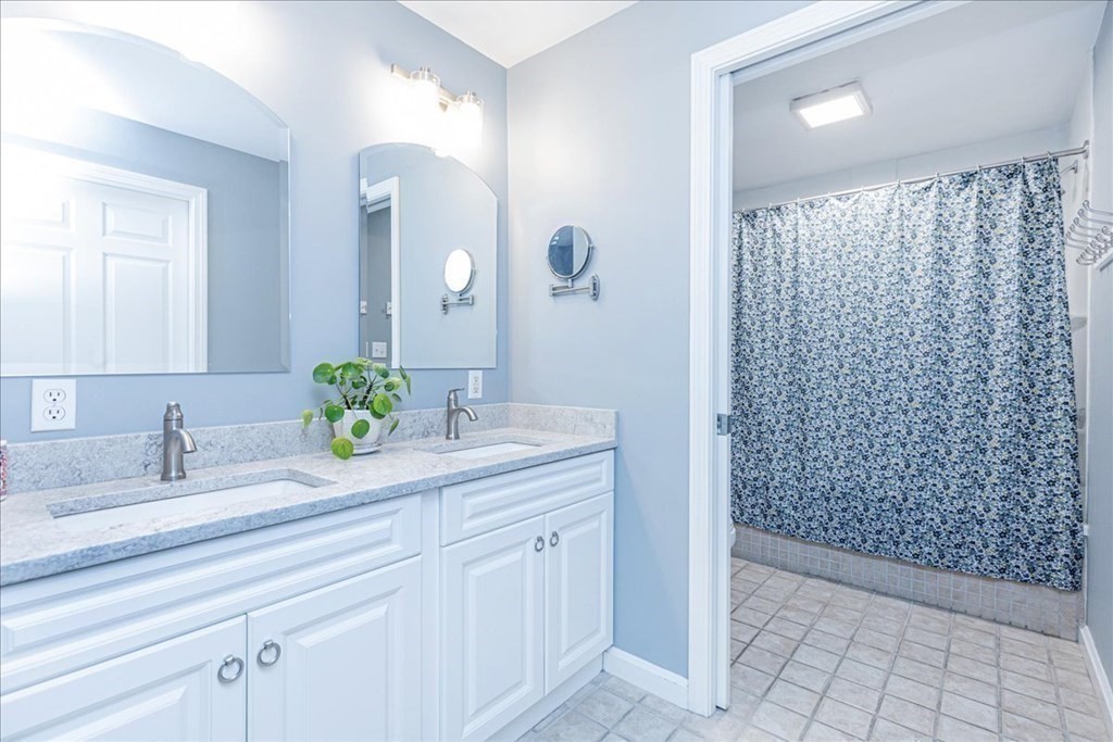 38 Village Road, Unit 312 Middleton, MA 01949 - Photo 26 of 42 a bathroom with a granite countertop sink a mirror and shower