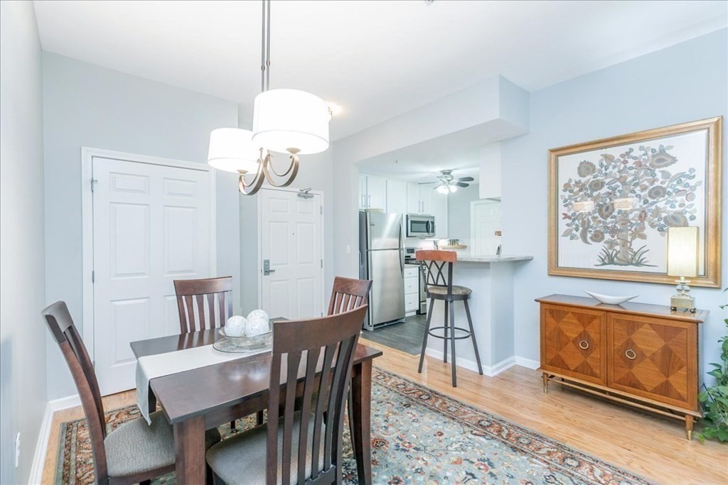 38 Village Road, Unit 312 Middleton, MA 01949 - Photo 6 of 42 a view of a dining room with furniture and a chandelier