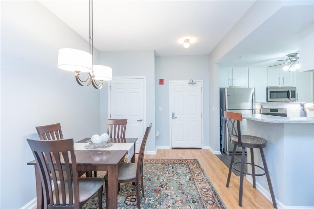 38 Village Road, Unit 312 Middleton, MA 01949 - Photo 7 of 42 a view of a dining room with furniture wooden floor and chandelier