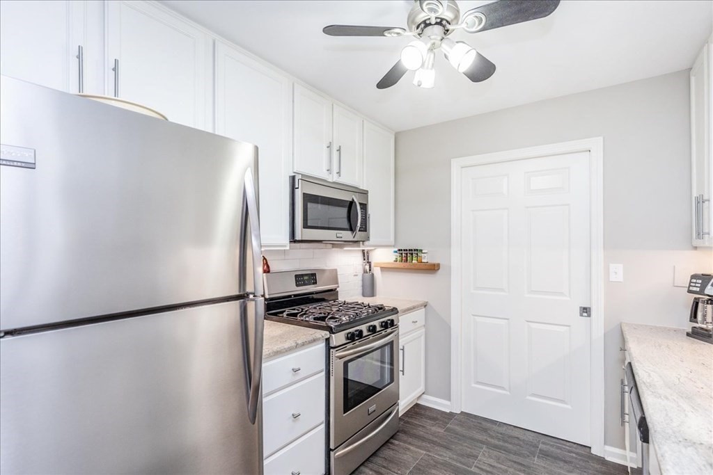 38 Village Road, Unit 312 Middleton, MA 01949 - Photo 8 of 42 a kitchen with stainless steel appliances a refrigerator a sink and white cabinets