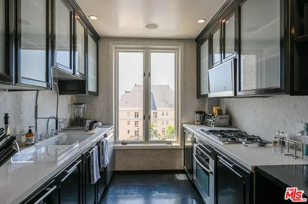 a kitchen with a sink a stove and cabinets
