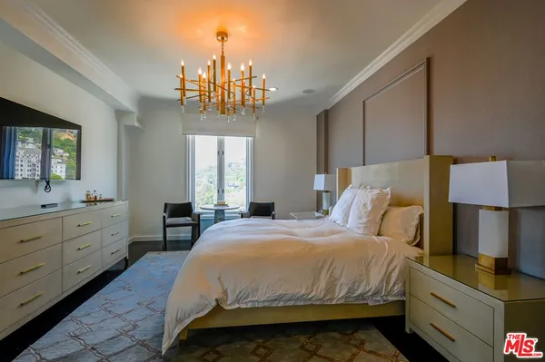 a bedroom with a bed and a chandelier