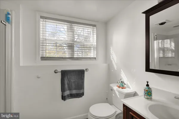 a bathroom with a toilet sink vanity and mirror