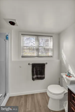 a bathroom with a toilet a sink and a window