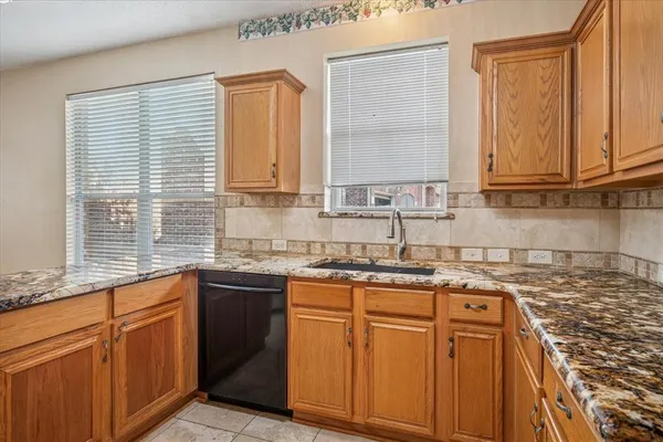 a kitchen with stainless steel appliances granite countertop a sink stove and cabinets