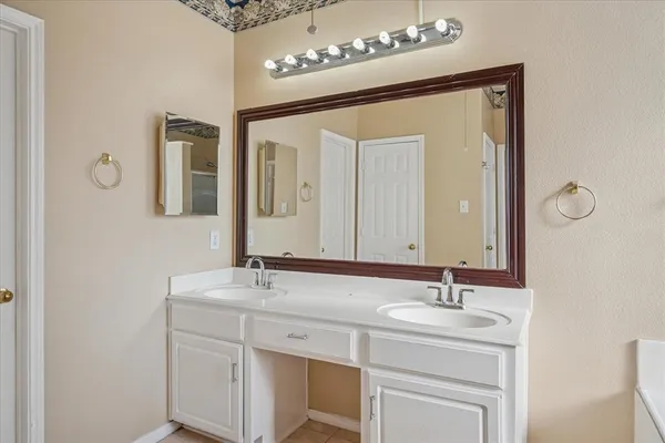a bathroom with a sink vanity and mirror