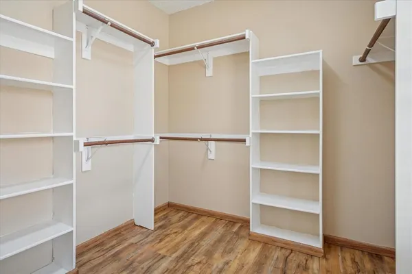 a view of walk in closet with empty racks