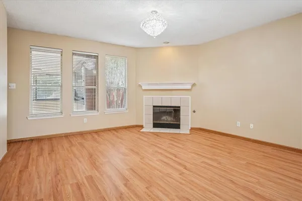 a view of empty room with wooden floor and fireplace