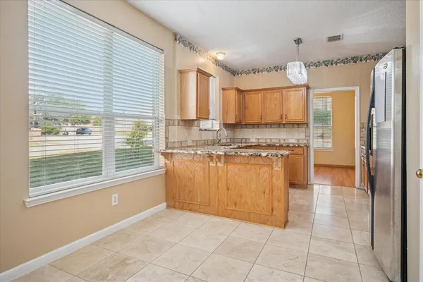 a kitchen with granite countertop a stove a sink and a refrigerator