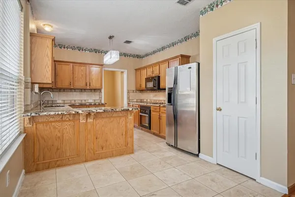 a kitchen with stainless steel appliances granite countertop a refrigerator and a sink