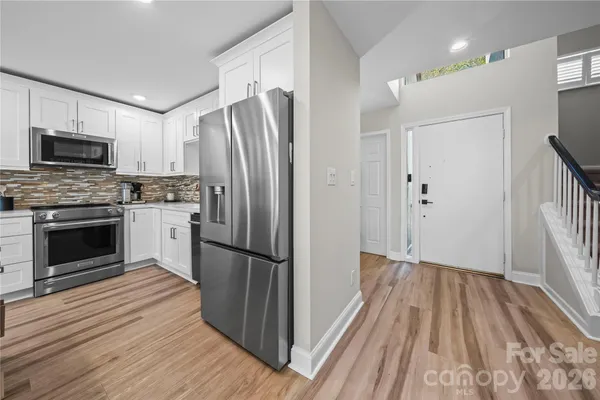 a kitchen with wooden floors a sink appliances and cabinets