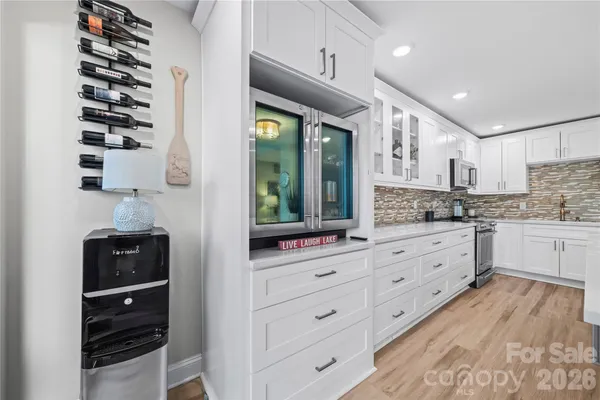 a kitchen with granite countertop a large window and white cabinets