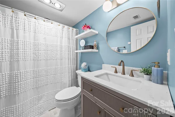 a bathroom with a sink a toilet and a mirror