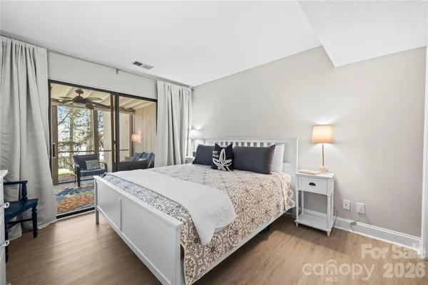 a large bedroom with a bed and wooden floor