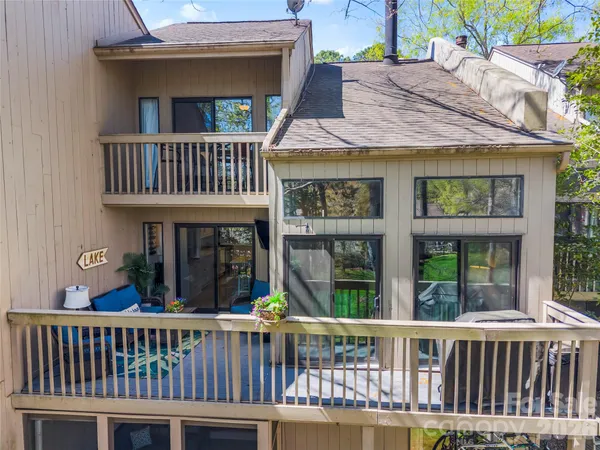 a view of a brick house with large windows and a deck