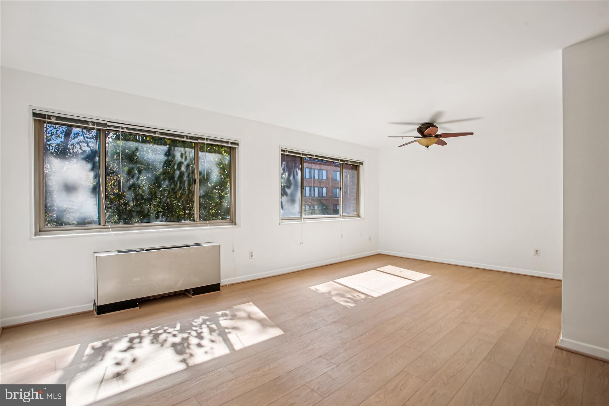 3900 Tunlaw Road Northwest, Unit 509 Washington, DC 20007 - Photo 3 of 19 a view of an empty room with a window and wooden floor