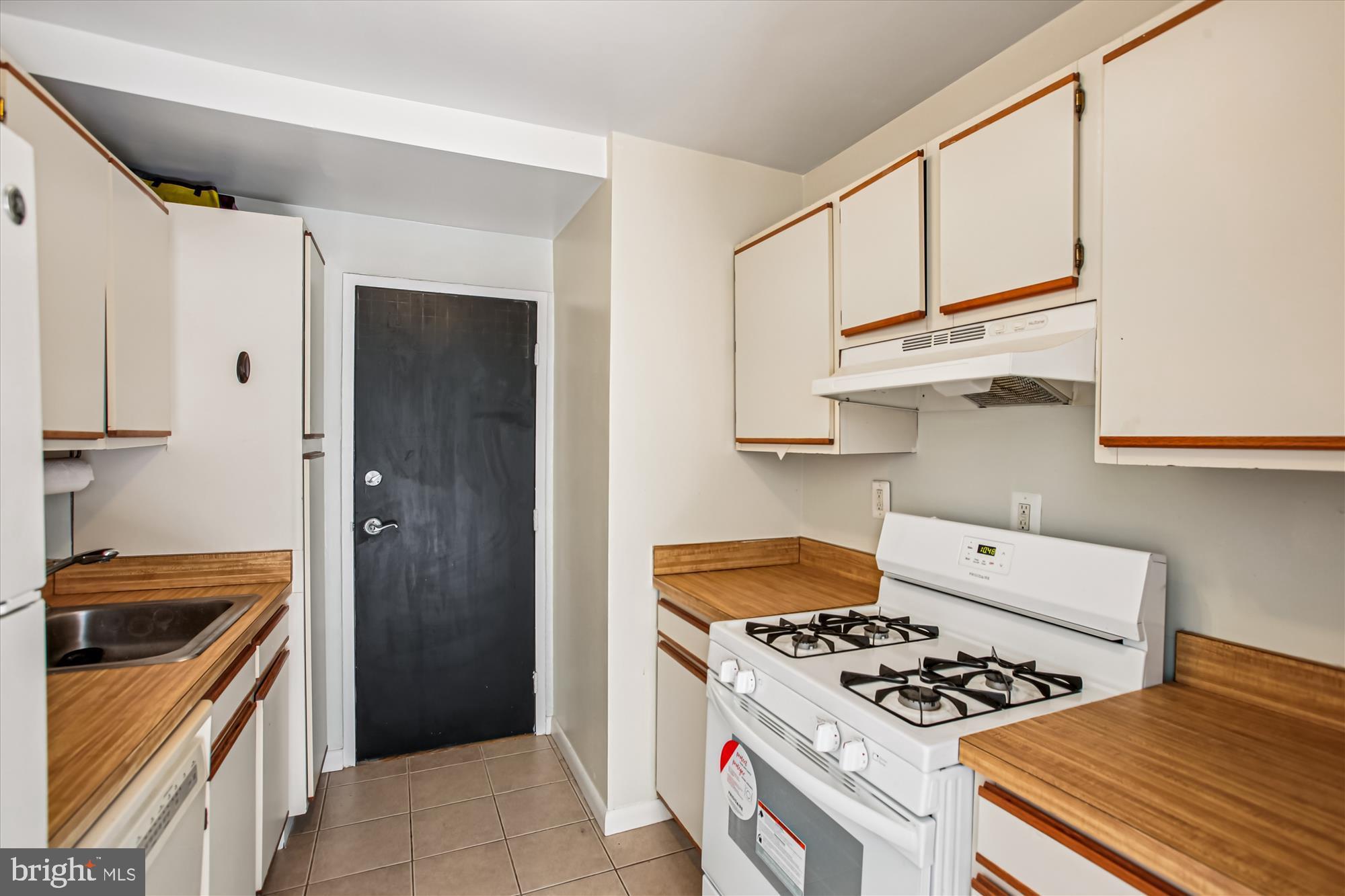 3900 Tunlaw Road Northwest, Unit 509 Washington, DC 20007 - Photo 7 of 19 a kitchen with white cabinets and appliances