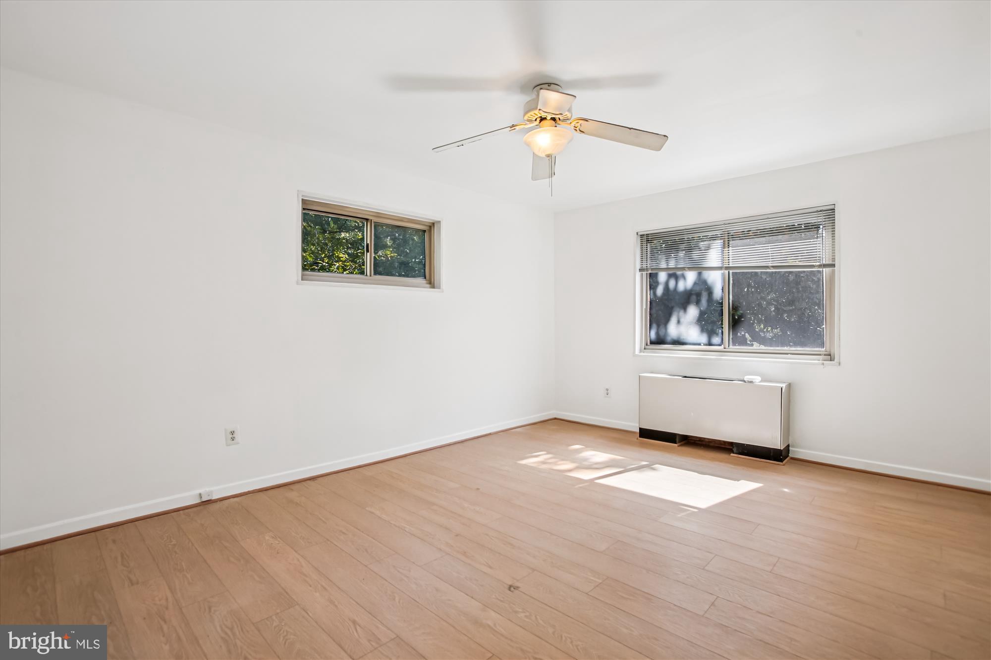 3900 Tunlaw Road Northwest, Unit 509 Washington, DC 20007 - Photo 9 of 19 a view of an empty room with a window and wooden floor