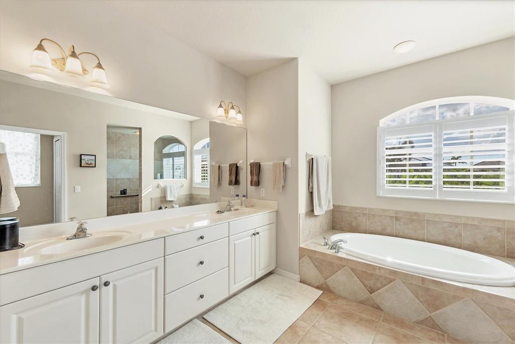 4 Windward Way Placida, FL 33946 - Photo 27 of 39 a spacious bathroom with a granite countertop tub a double vanity sink a window a mirror and