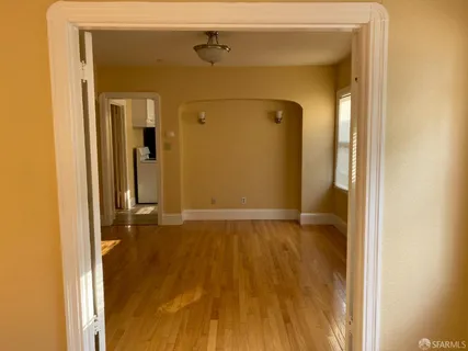 a view of empty room with wooden floor
