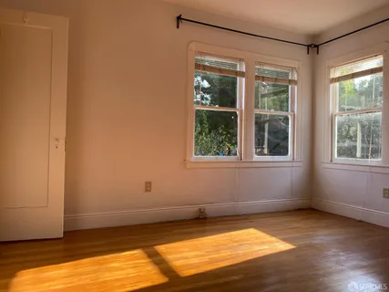 a view of a room with wooden floor and windows