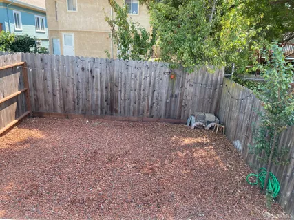 a view of backyard with wooden fence