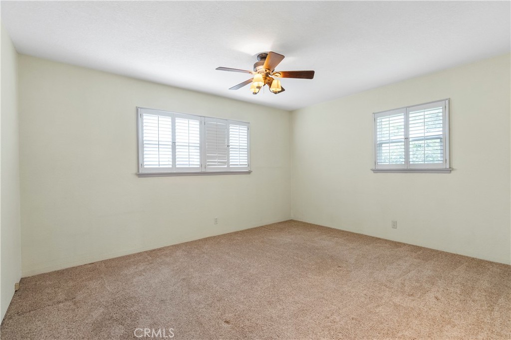 4669 Edgewood Place Riverside, CA 92506 - Photo 20 of 26 an empty room with windows and fan