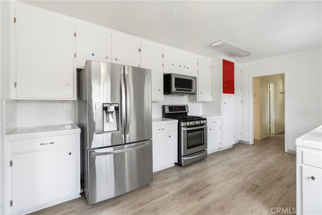 4669 Edgewood Place Riverside, CA 92506 - Photo 7 of 26 a kitchen with stainless steel appliances a refrigerator stove and sink