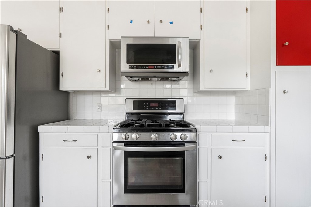 4669 Edgewood Place Riverside, CA 92506 - Photo 8 of 26 a kitchen with stainless steel appliances a stove a microwave and cabinets