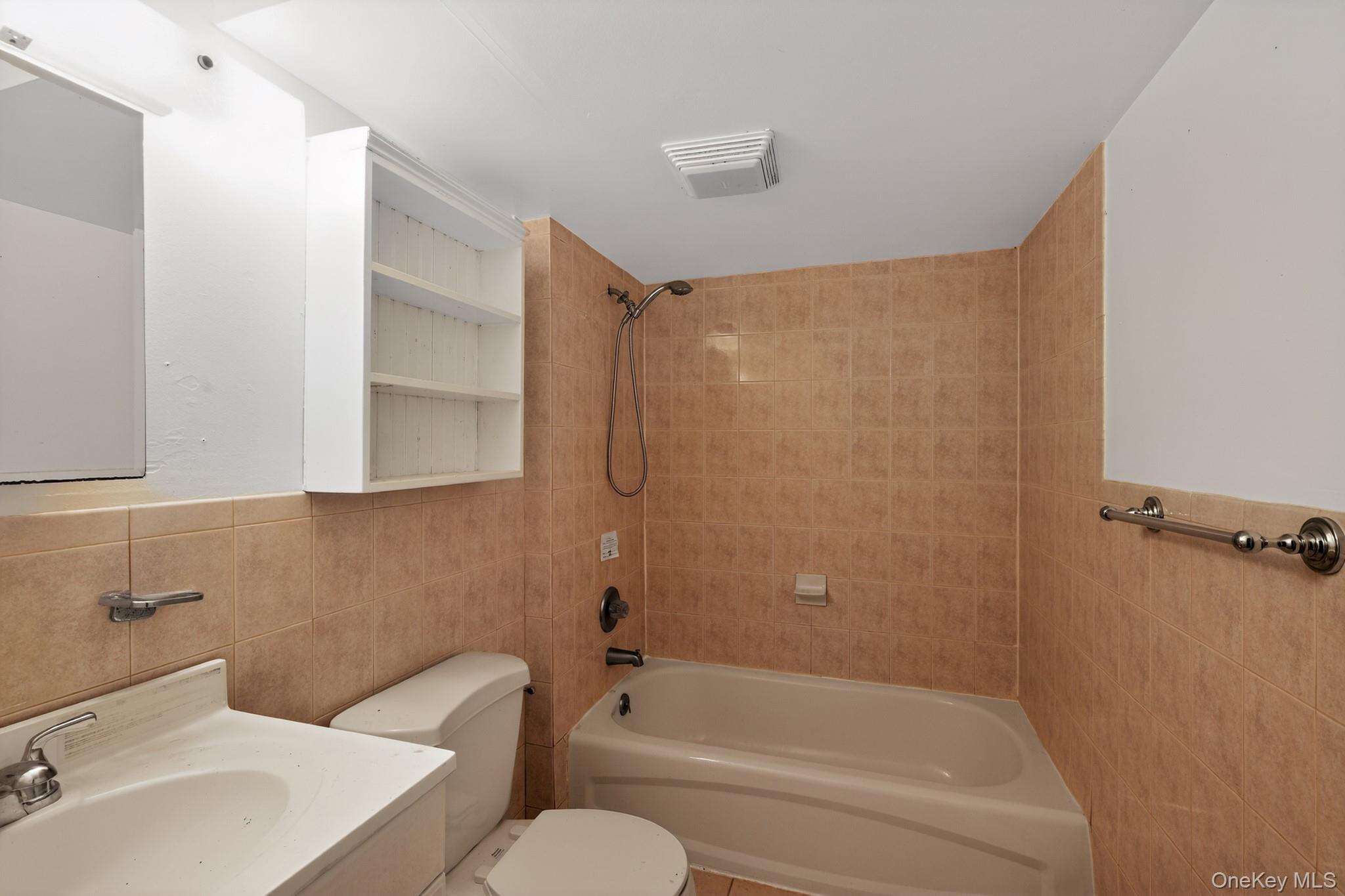 138 Spring Street Massapequa, NY 11758 - Photo 30 of 45 a bathroom with a toilet and a bathtub